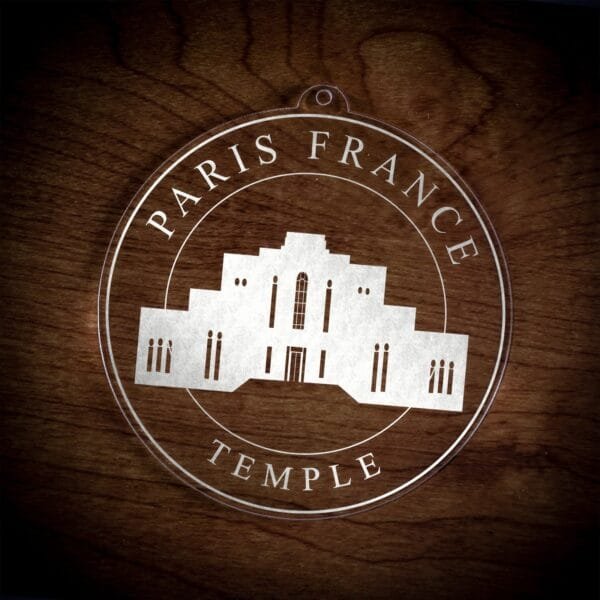 LDS Paris France Temple Christmas Ornament laying on a Wooden Background
